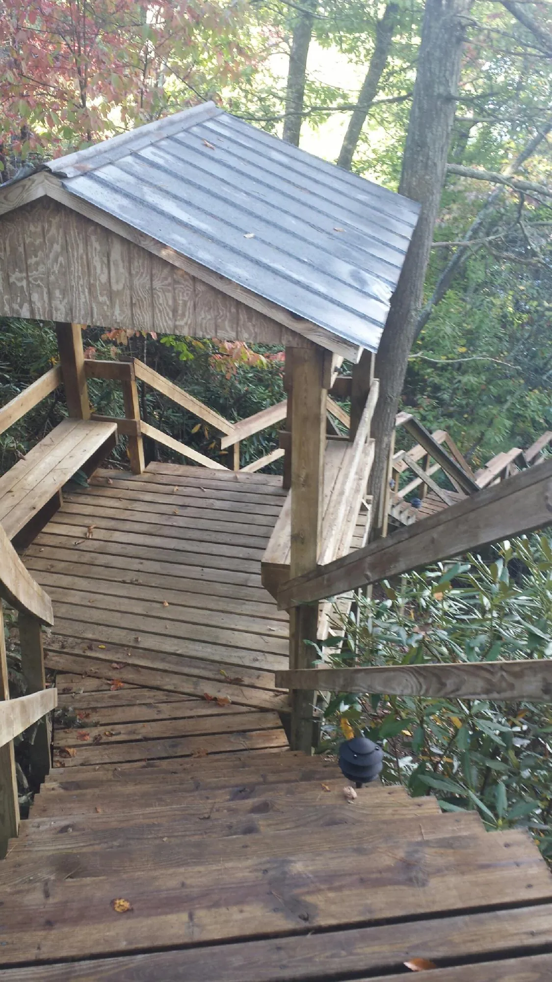 Metal roofed shelter over wooden steps on a wooded walkway — Skylight Repair & Installation work by our crew in Parlin